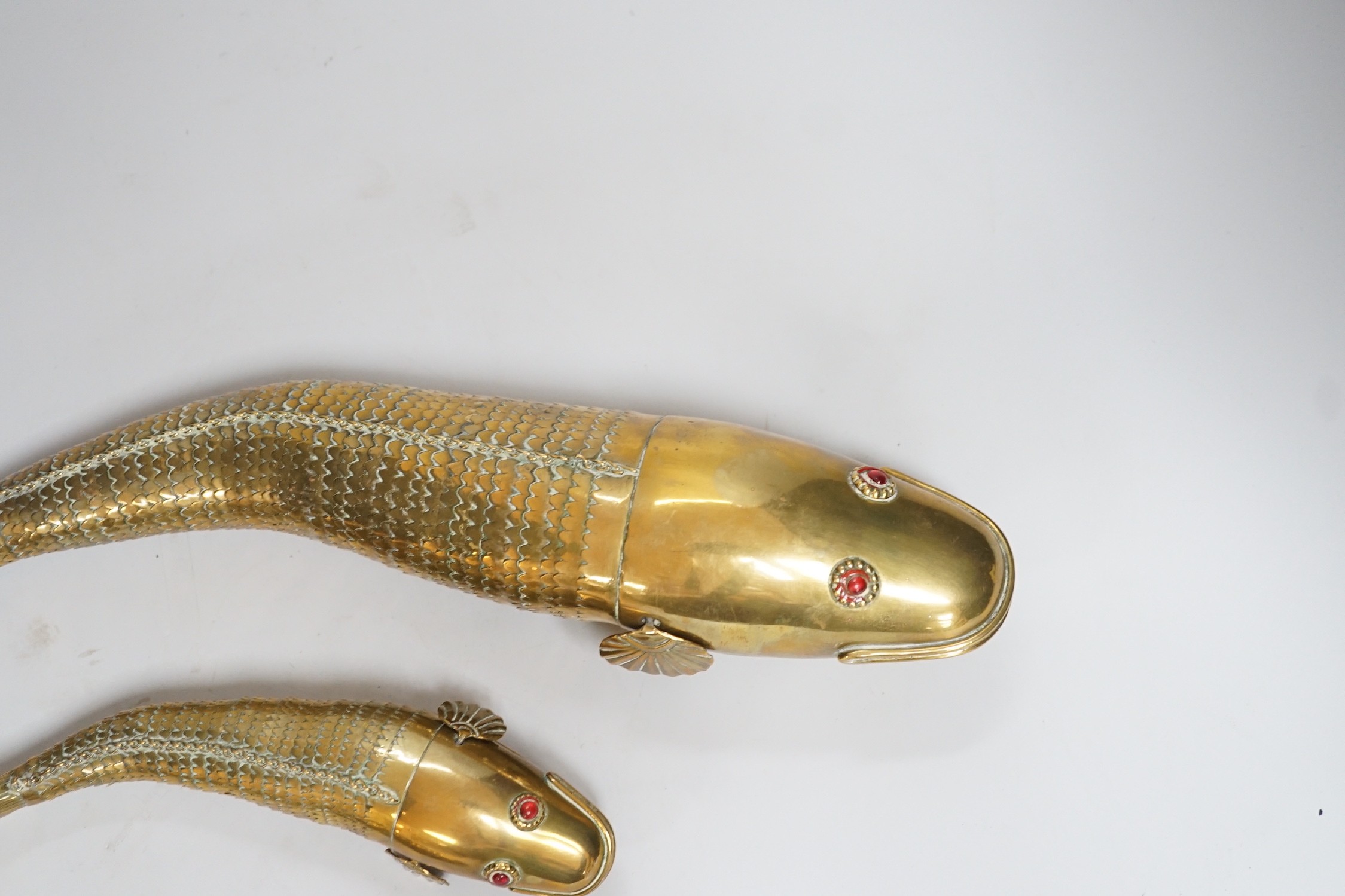 A set of three graduated brass articulated fish, largest 43.3cms long